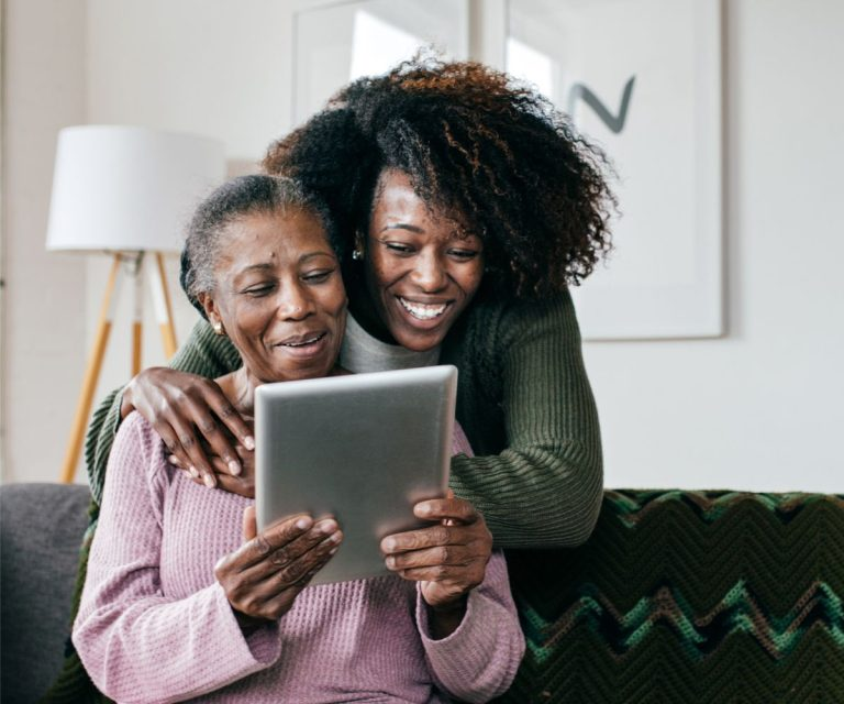 Caregiver and client looking at tablet together