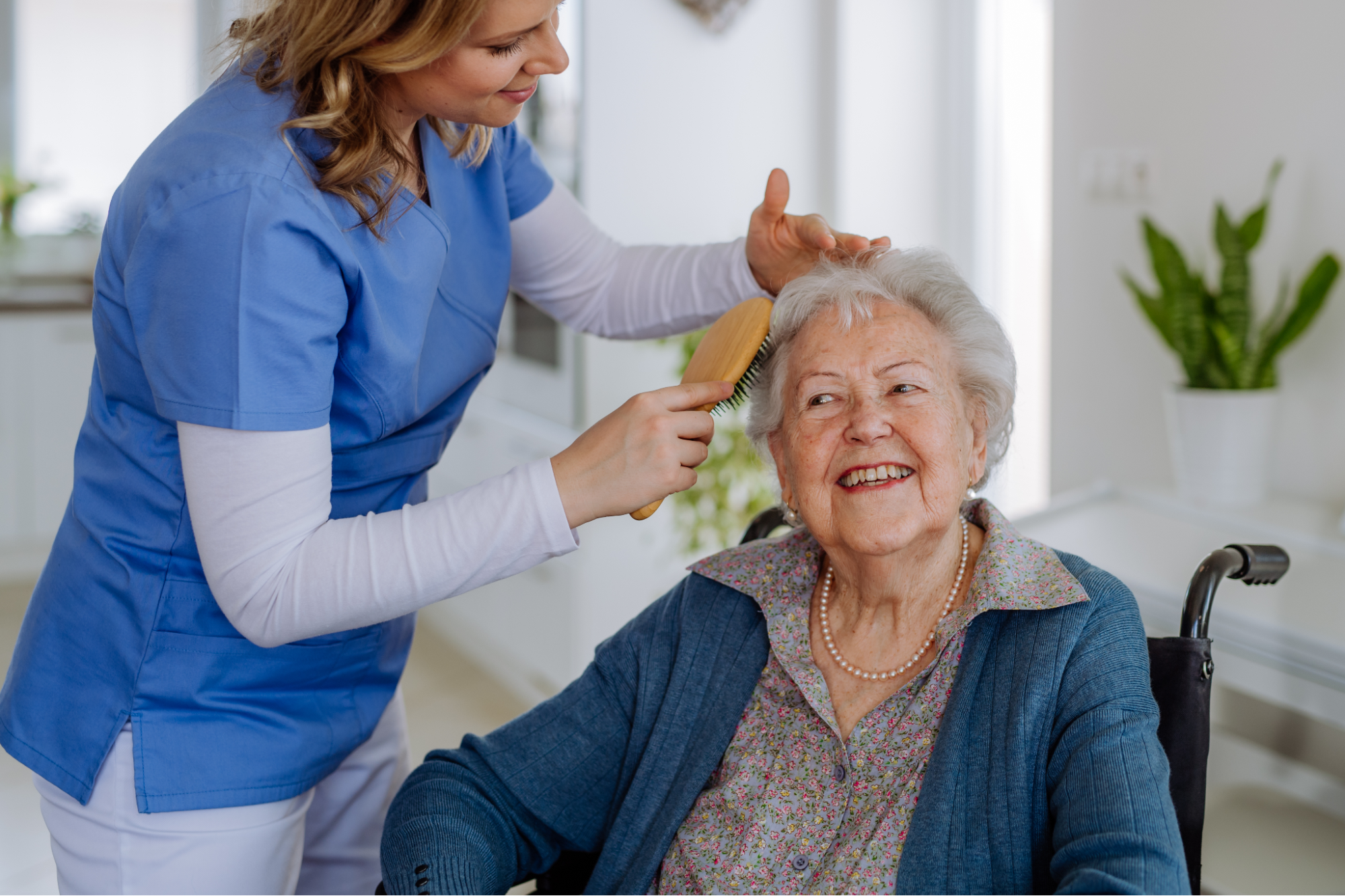 Caregiver covering elderly woman with blanket
